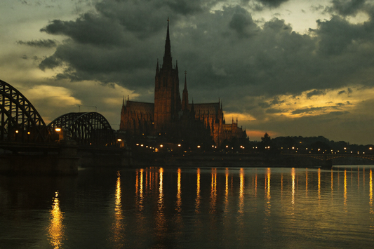 Gotische Kathedrale und Bogenbrücke an einem Fluss in der Abenddämmerung